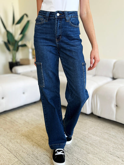 Judy Blue full size high waist straight cargo jeans with pocket detailing, worn by a person standing indoors.