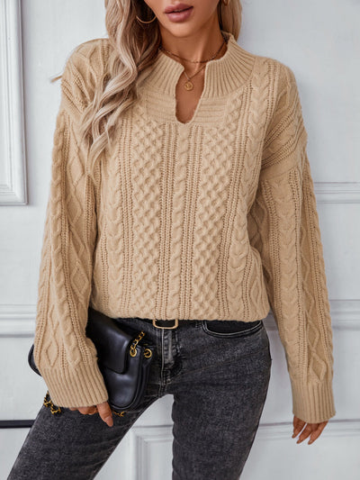 Cable-knit notched long sleeve sweater in beige with intricate patterns.