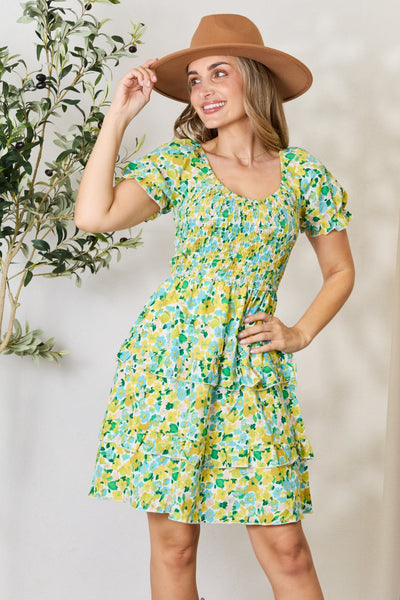 Floral patterned smocked mini dress with scoop neck and flounce sleeves.