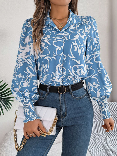 Printed collared neck lantern sleeve shirt with floral design in blue and white, paired with jeans and a white handbag.